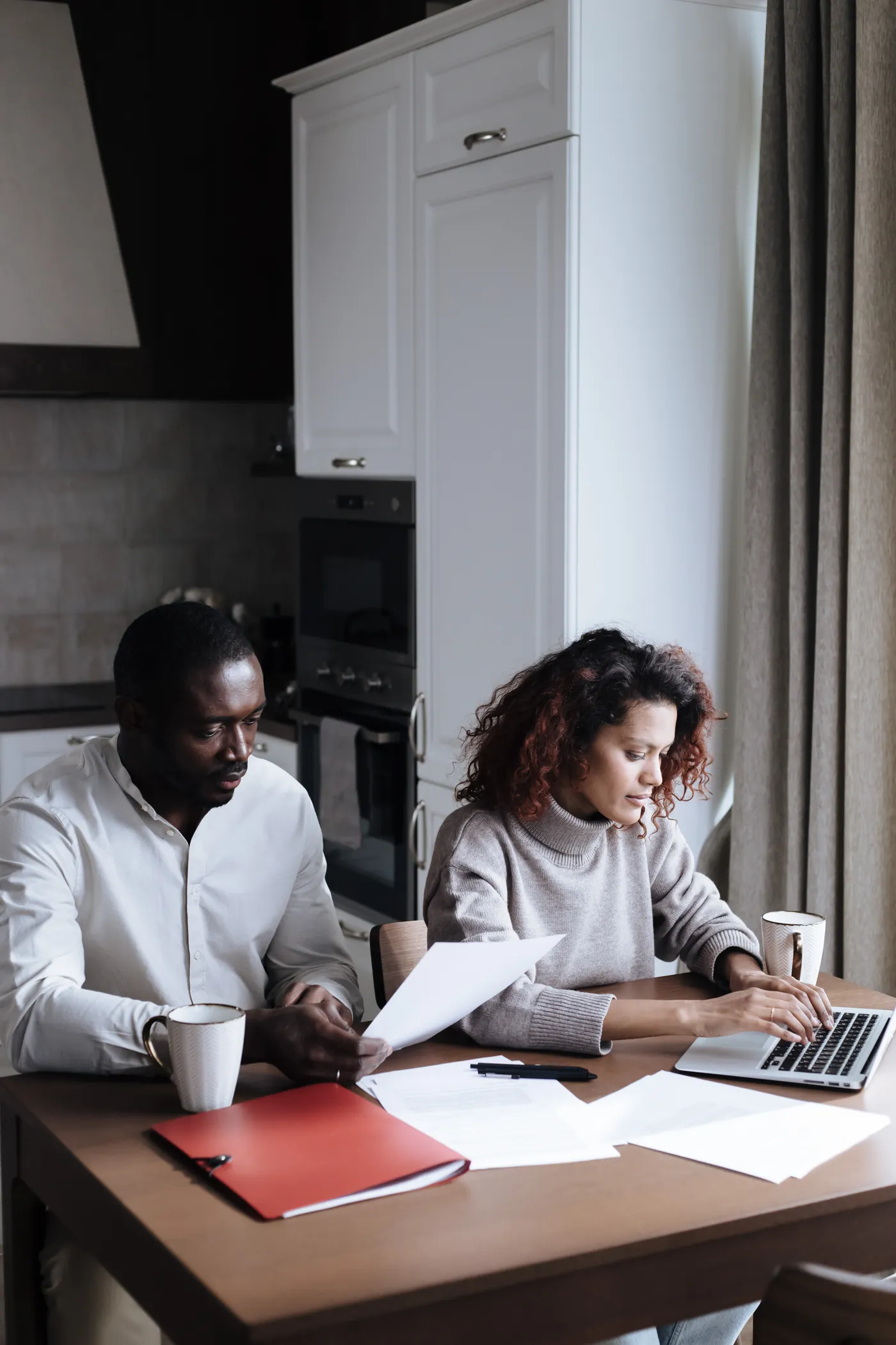 Household members reviewing laptop assistance information and documents at home