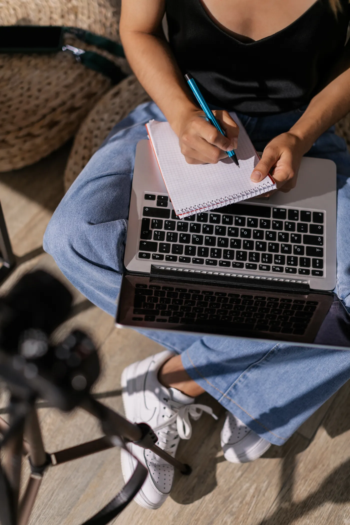 Adult learner taking notes while using a laptop for online study