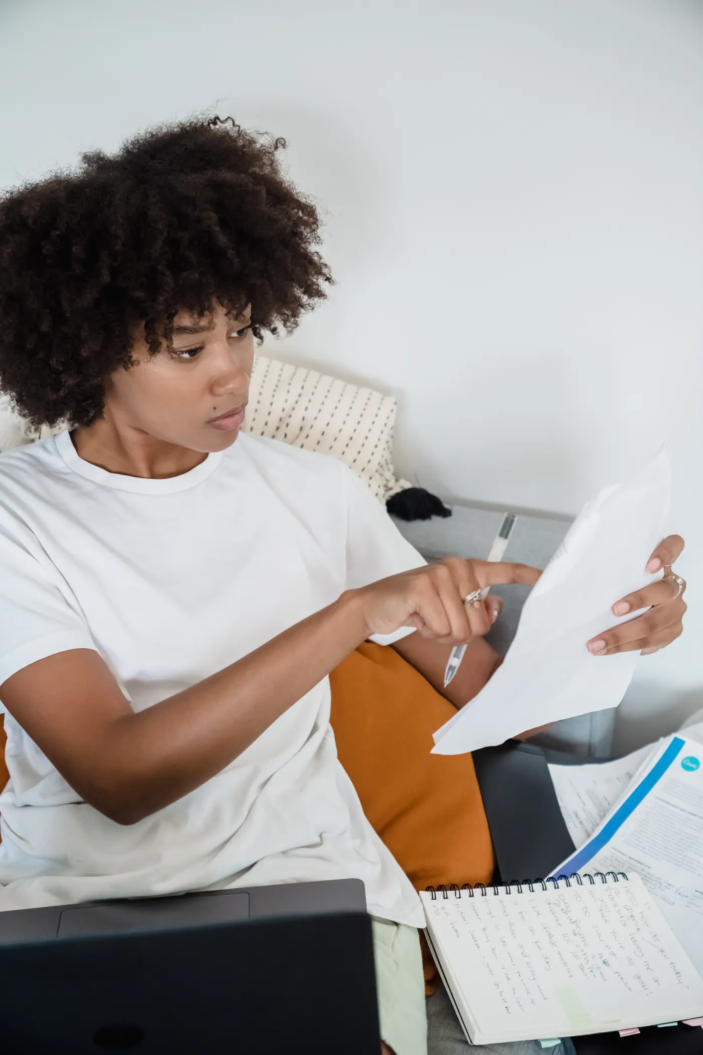 Person reviewing household documents beside a laptop