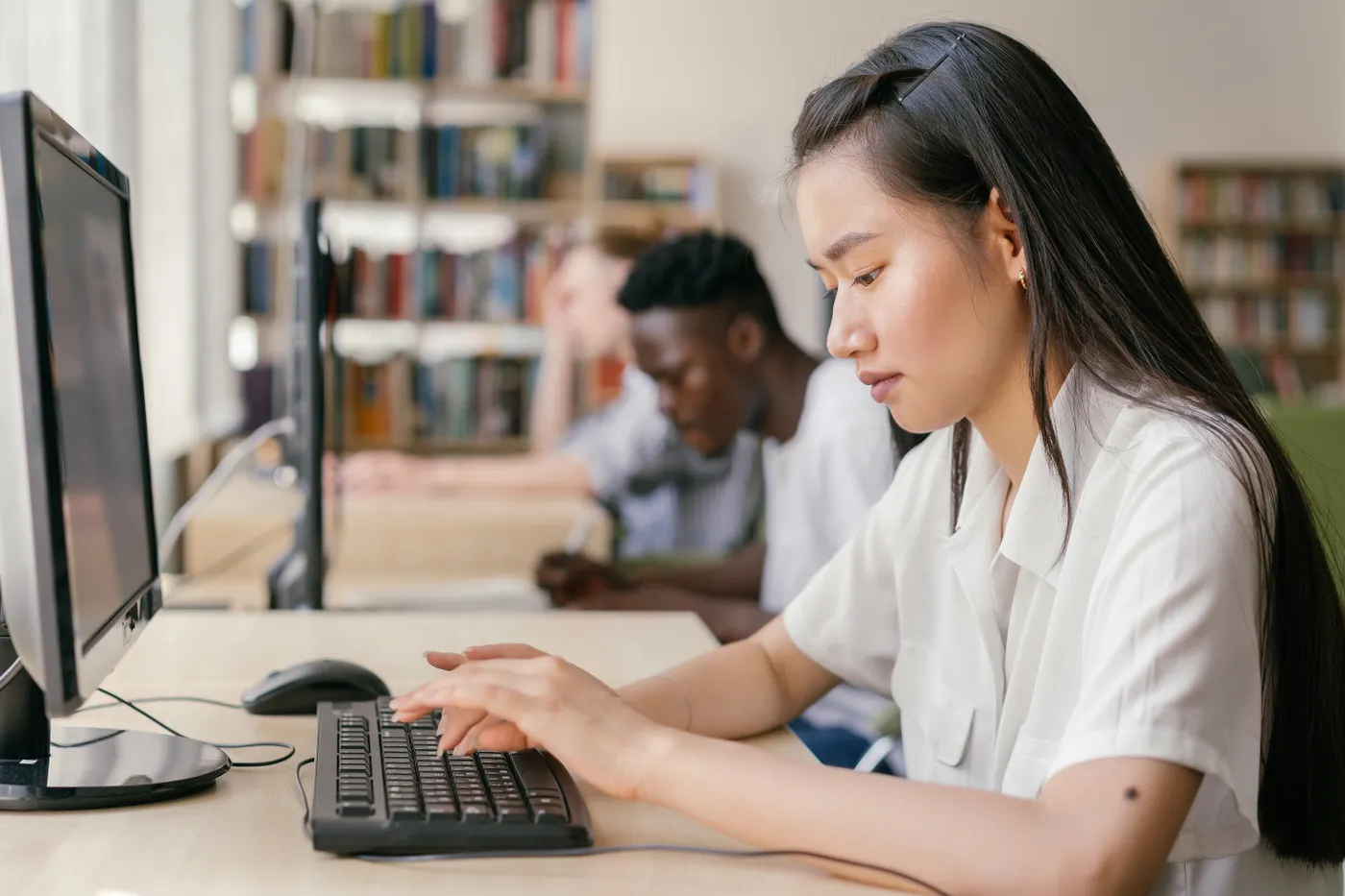 Students comparing computer options while studying in a library