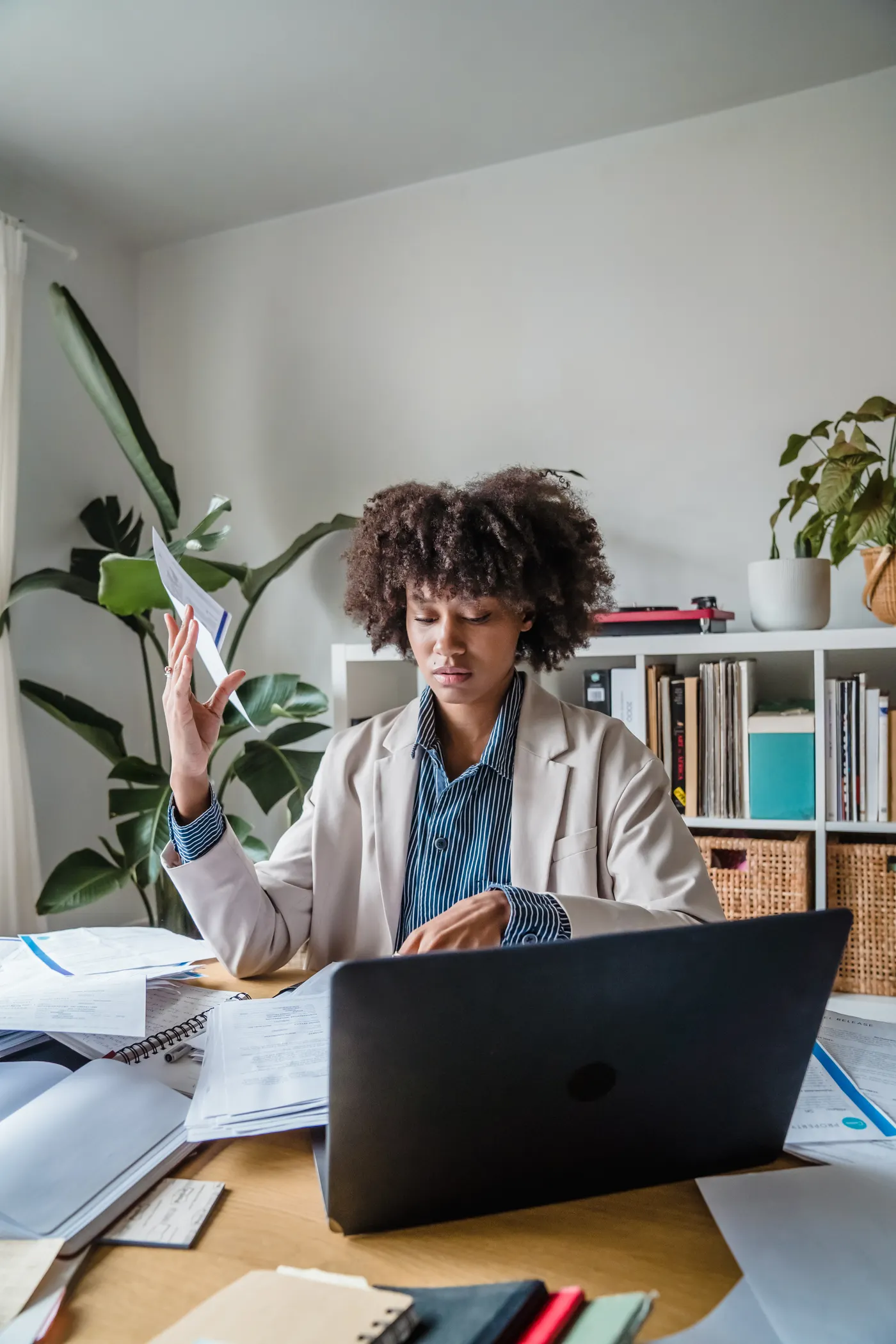 Person organizing eligibility documents beside a laptop at home