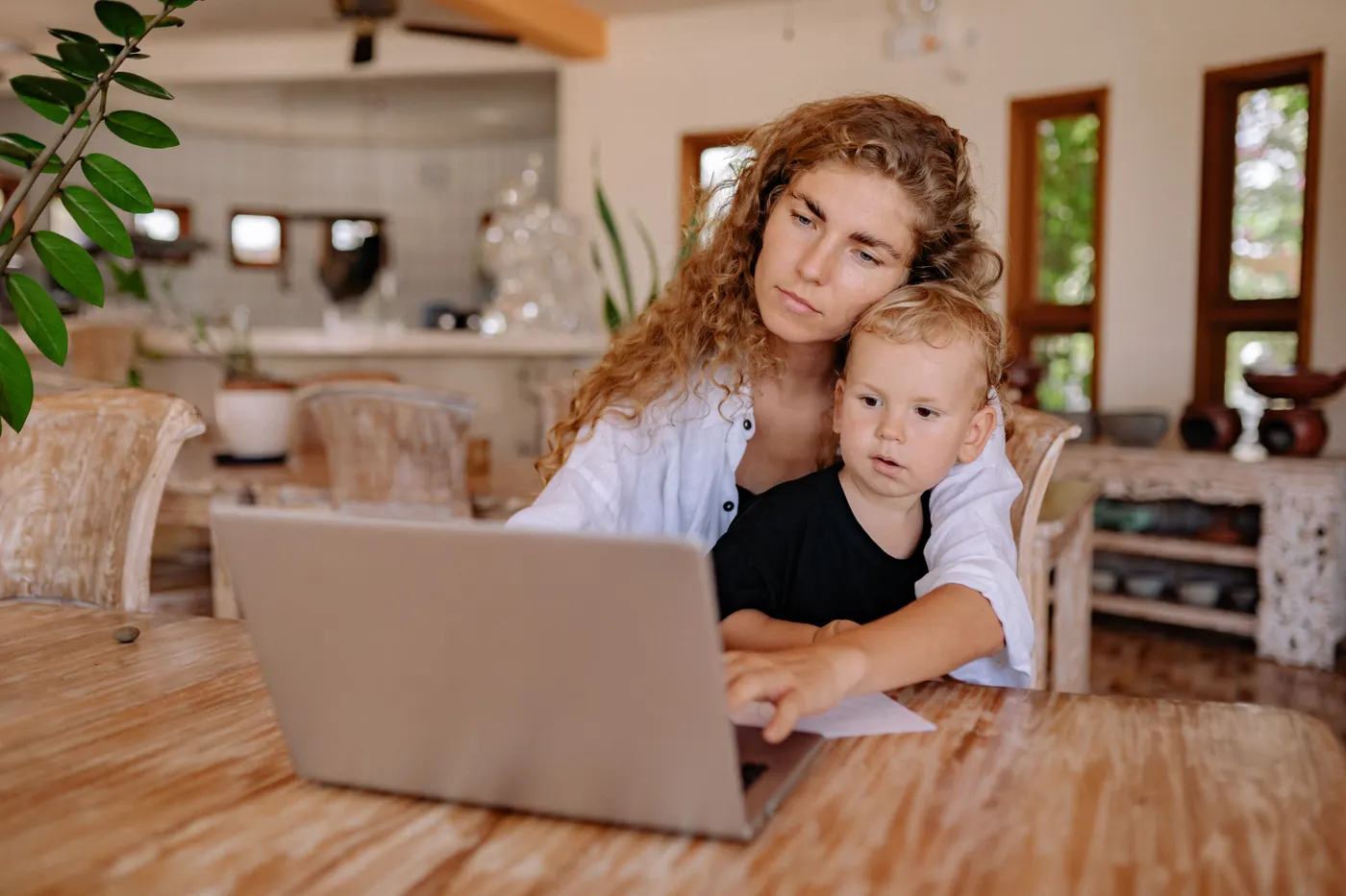 Parent and child using a laptop together in a home setting
